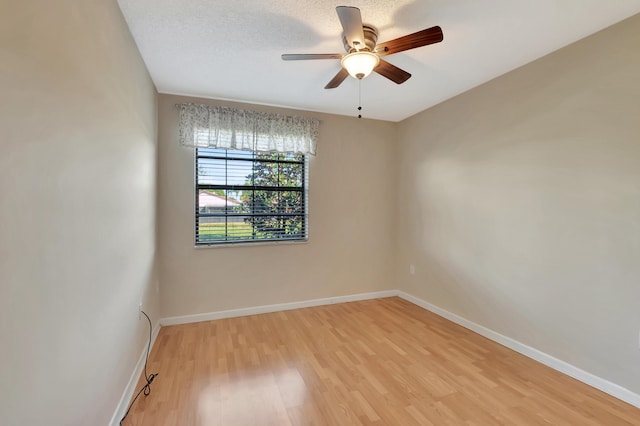 unfurnished room with ceiling fan, light wood-type flooring, and a textured ceiling