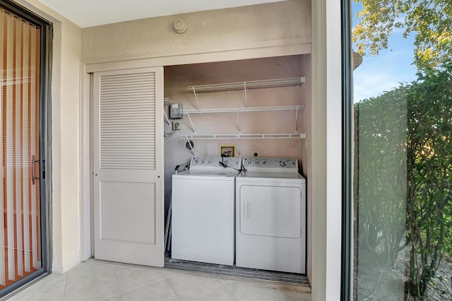 laundry area with washer and clothes dryer and light tile patterned floors