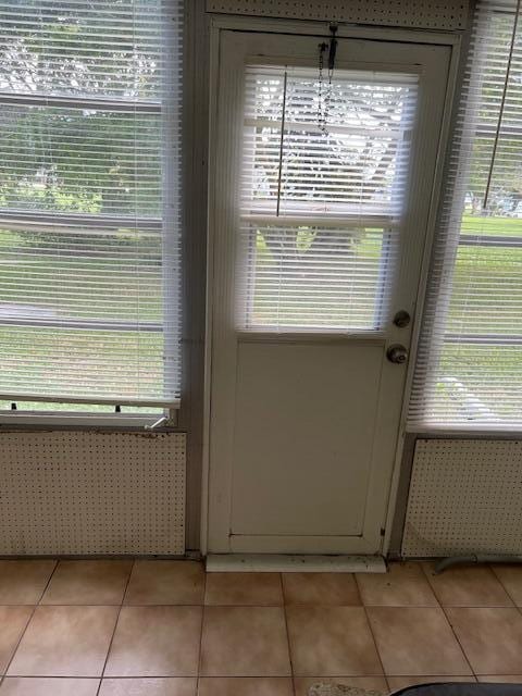 entryway featuring radiator heating unit, a healthy amount of sunlight, and light tile patterned floors