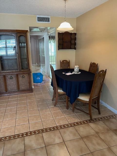 tiled dining area with a textured ceiling