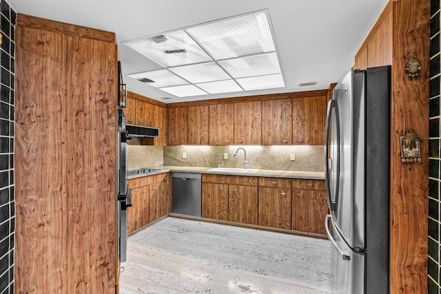 kitchen featuring light hardwood / wood-style flooring, stainless steel appliances, ventilation hood, sink, and tasteful backsplash