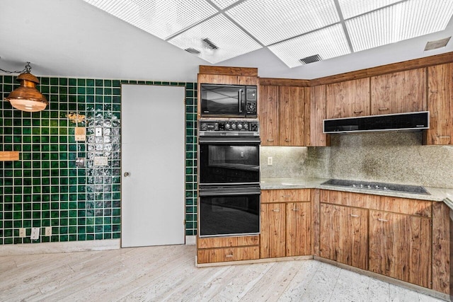 kitchen featuring tasteful backsplash, black appliances, exhaust hood, and light wood-type flooring