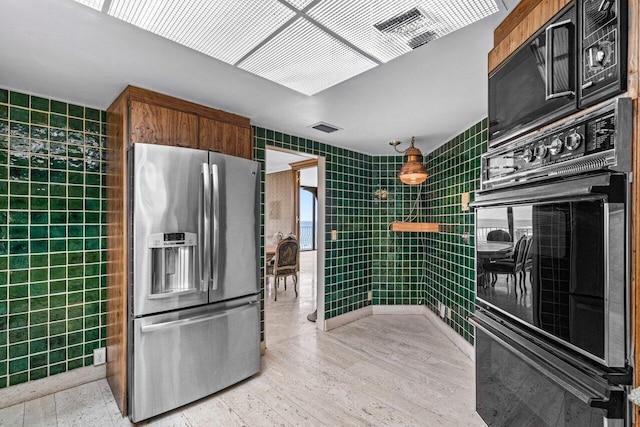 kitchen with tile walls, black appliances, and light hardwood / wood-style flooring