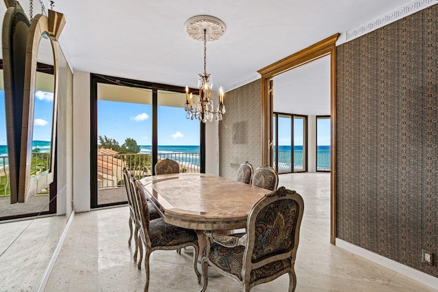 dining area with plenty of natural light, a chandelier, and a water view