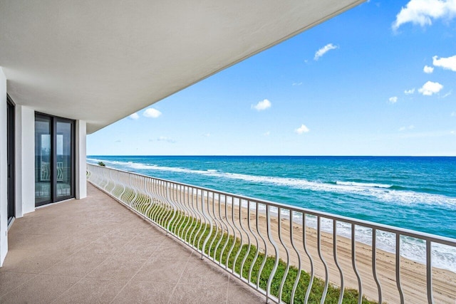 balcony with a water view and a beach view