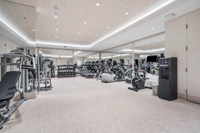 workout area with light carpet and a tray ceiling