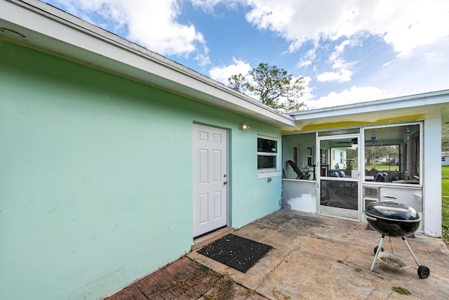 view of exterior entry with a patio