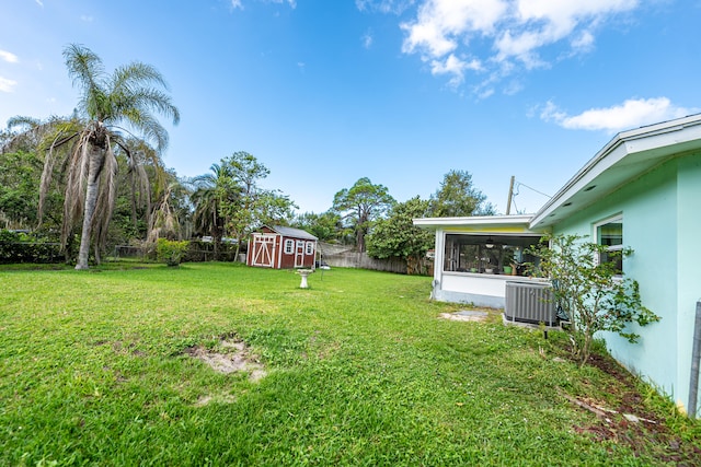 view of yard featuring a storage unit, central AC unit, and a sunroom