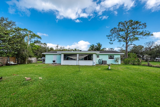 rear view of property featuring a lawn and a sunroom