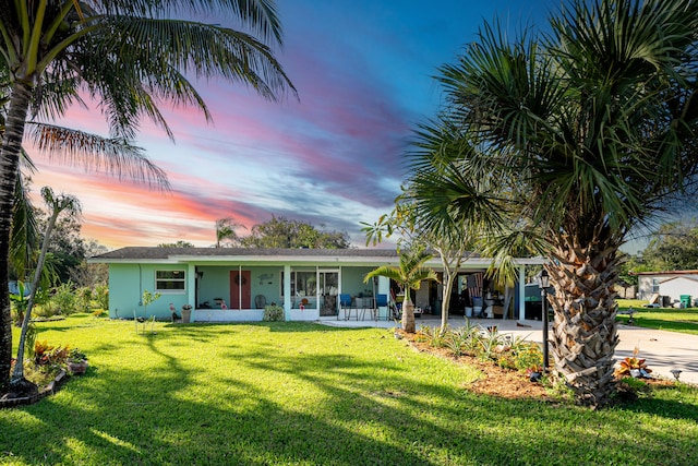 view of front facade with covered porch and a lawn