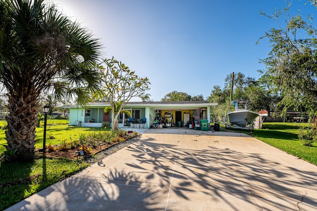 ranch-style house featuring covered porch and a front yard