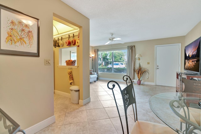 dining space featuring a textured ceiling, light tile patterned floors, and ceiling fan