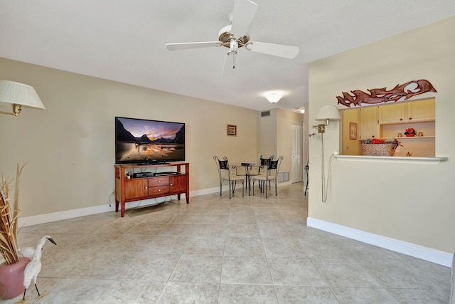 living room with a textured ceiling, light tile patterned floors, and ceiling fan