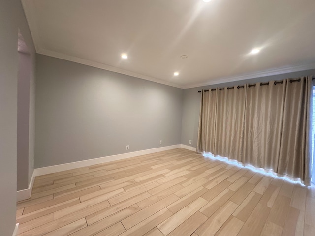 unfurnished room with ornamental molding and light wood-type flooring