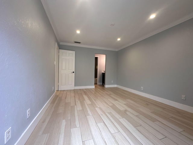 empty room featuring crown molding and light wood-type flooring