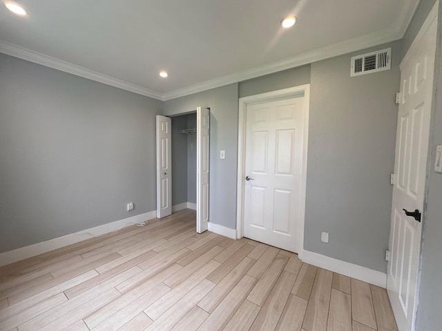 unfurnished bedroom with ornamental molding and light wood-type flooring