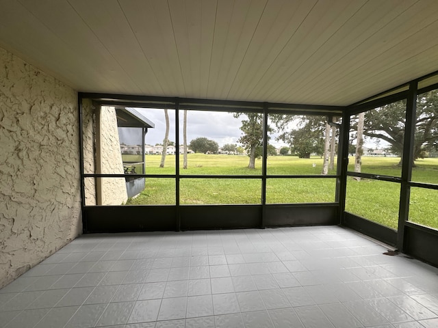 unfurnished sunroom featuring wood ceiling and plenty of natural light