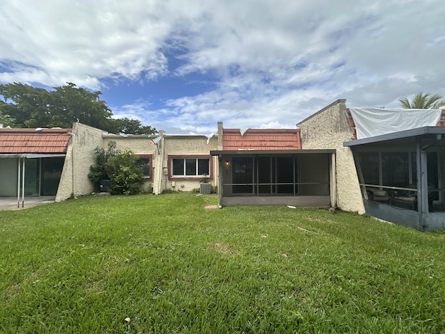 back of house featuring central AC, a lawn, and a sunroom