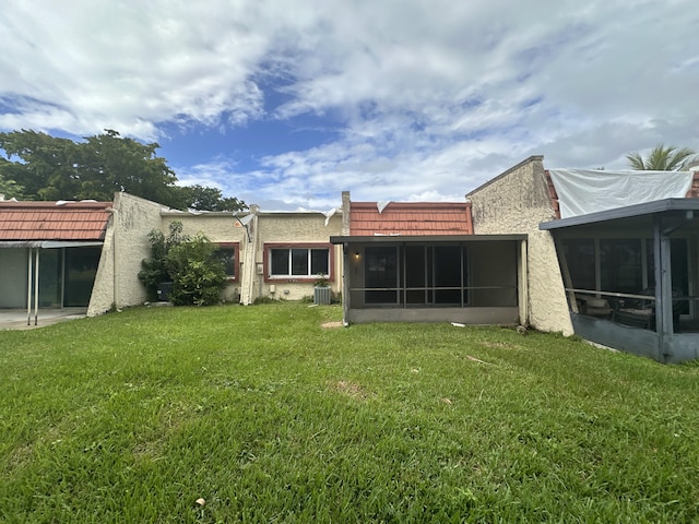 9638 NW 65th St Unit C10, Tamarac, FL 33321 - back of property with a sunroom, a lawn, central AC unit, and stucco siding