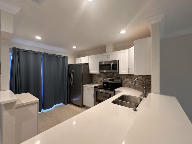 kitchen with decorative backsplash, appliances with stainless steel finishes, white cabinetry, ornamental molding, and sink