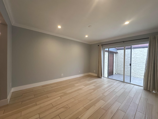 empty room with ornamental molding and light hardwood / wood-style floors