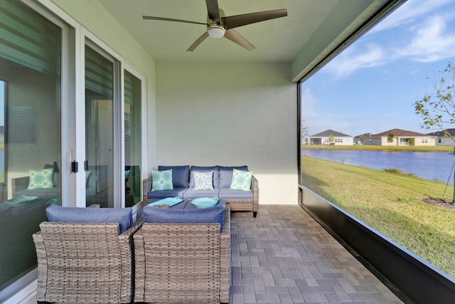 sunroom / solarium with a water view and ceiling fan