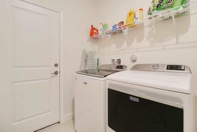 washroom featuring washing machine and dryer and light tile patterned flooring