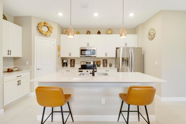 kitchen featuring white cabinets, a kitchen island with sink, stainless steel appliances, and sink