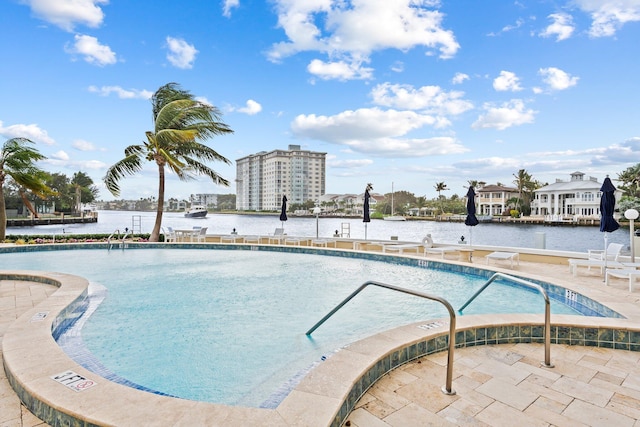 view of pool with a water view and a patio area