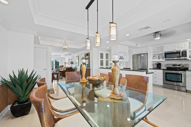 tiled dining area with a raised ceiling and ornamental molding