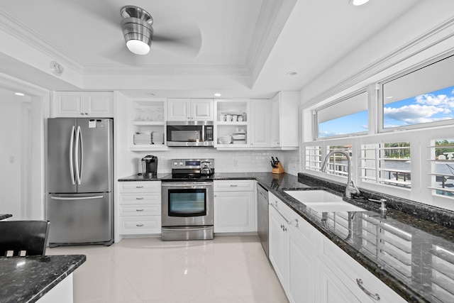 kitchen with white cabinetry, sink, appliances with stainless steel finishes, dark stone countertops, and backsplash