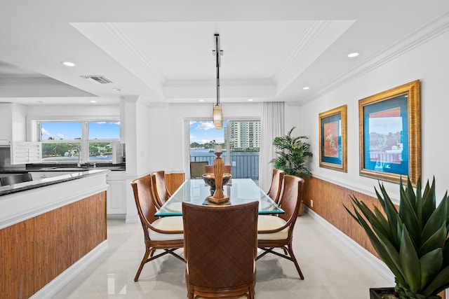 dining space featuring crown molding and a tray ceiling