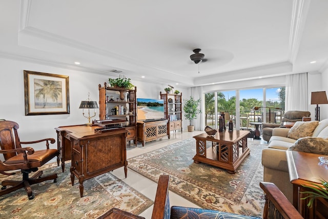 living room featuring ornamental molding, a tray ceiling, light tile patterned floors, and ceiling fan