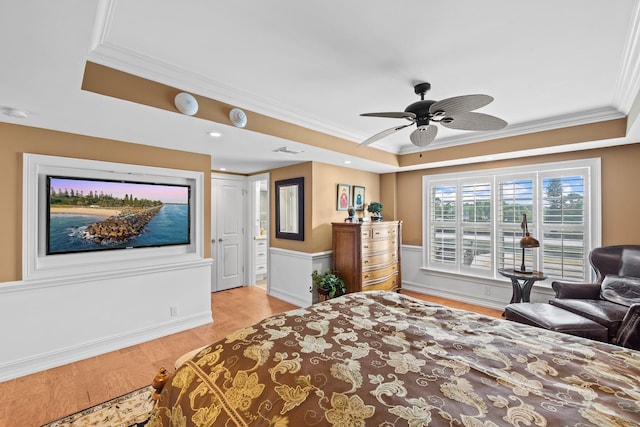 bedroom featuring ornamental molding, light hardwood / wood-style floors, ceiling fan, and a raised ceiling