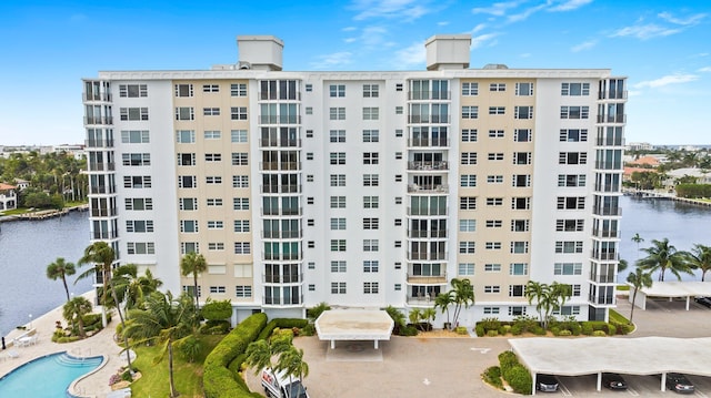 view of building exterior featuring a pool and a water view