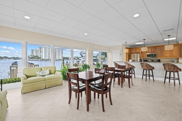 tiled dining space with a water view and plenty of natural light