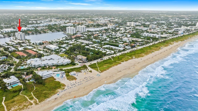 birds eye view of property featuring a water view and a beach view