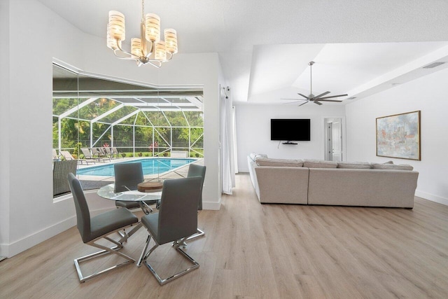 dining room featuring ceiling fan with notable chandelier, light hardwood / wood-style floors, and a healthy amount of sunlight