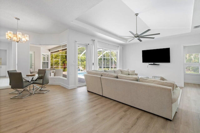 living room with ceiling fan, vaulted ceiling, light hardwood / wood-style floors, and plenty of natural light