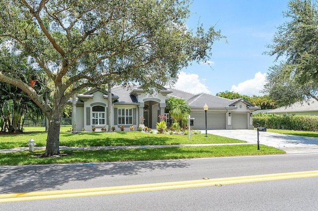 view of front of house with a garage and a front lawn