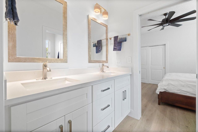 bathroom with hardwood / wood-style floors, ceiling fan, and vanity