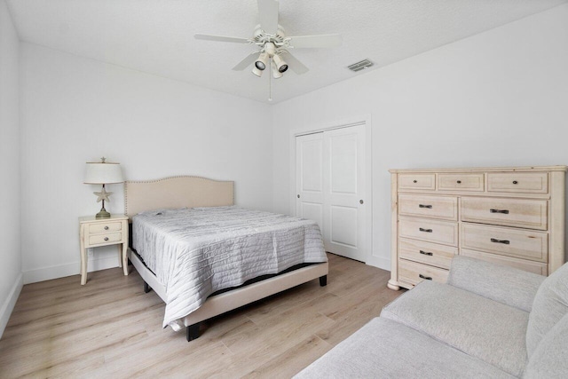 bedroom with a closet, light wood-type flooring, and ceiling fan