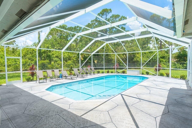 view of swimming pool featuring glass enclosure and a patio