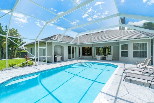 view of pool featuring a lanai, a grill, and a patio area