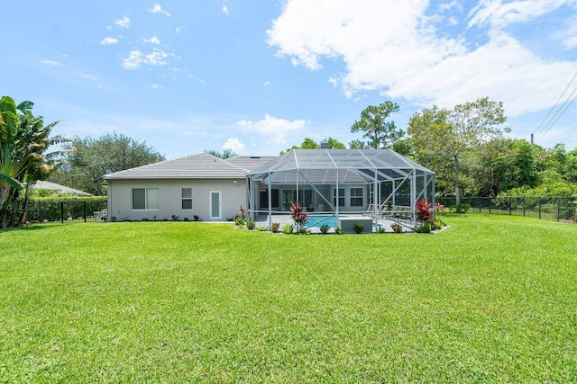 rear view of property with glass enclosure, a yard, and a fenced in pool