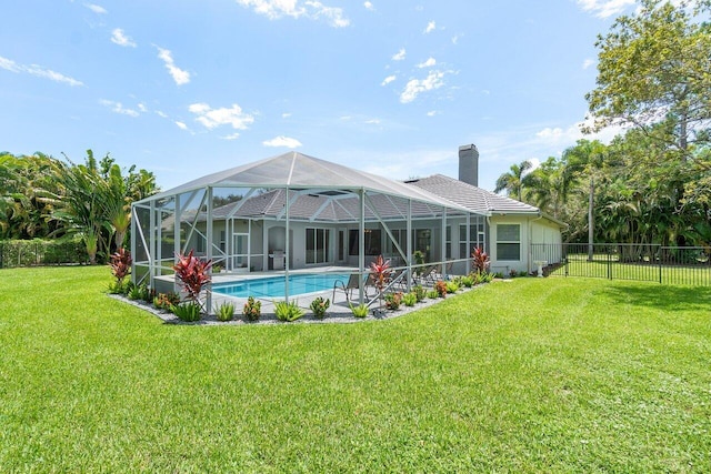 rear view of house with a fenced in pool, a yard, and a lanai