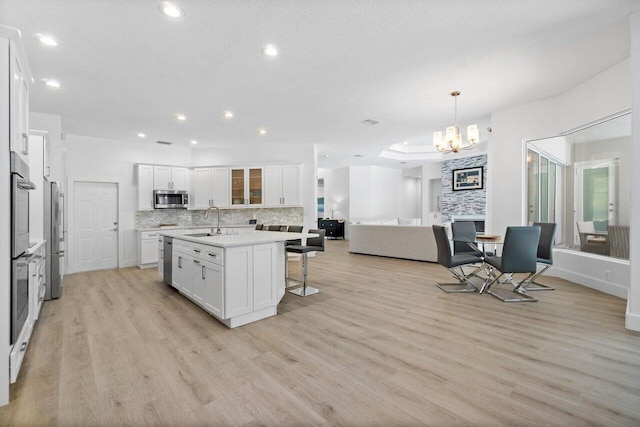 kitchen with light hardwood / wood-style flooring, appliances with stainless steel finishes, sink, and white cabinets