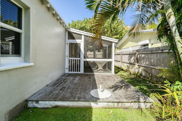 view of patio featuring a wooden deck and a sunroom