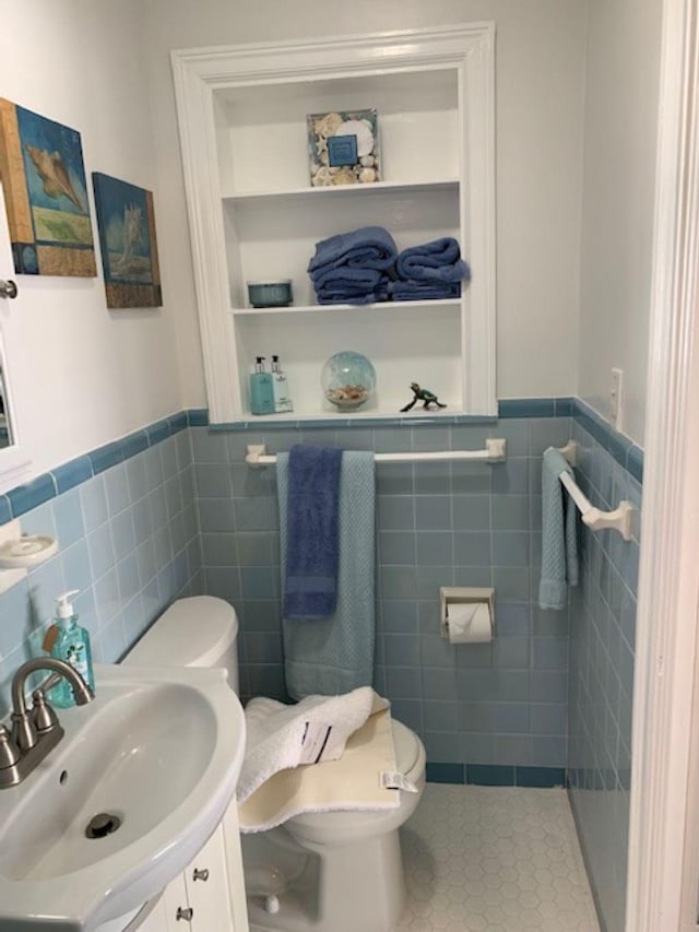 bathroom featuring tile walls, vanity, toilet, and tile patterned floors