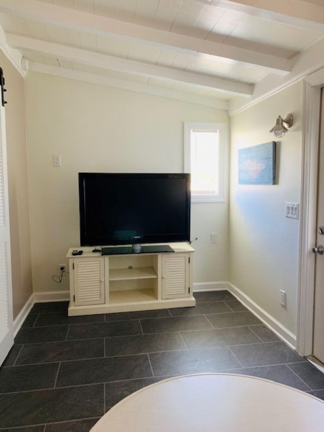 unfurnished living room with a barn door, lofted ceiling with beams, and dark tile patterned flooring